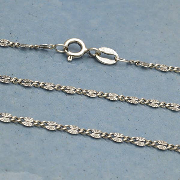 This sterling silver 18 inch sunburst chain necklace is perfect for pairing with a charm necklace! This sterling silver chain necklace has light oxidation. This finished chain features dainty sunburst oval links. Perfect piece for layering or a neck mess. 
