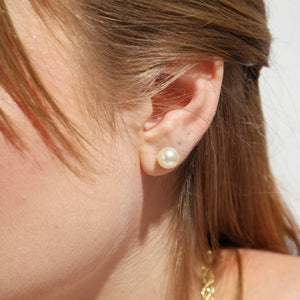Close-up of an ear wearing a pearl earring with blurred background. Shop Rutledge Exchange for curated vintage and jewelry in Camden, SC.