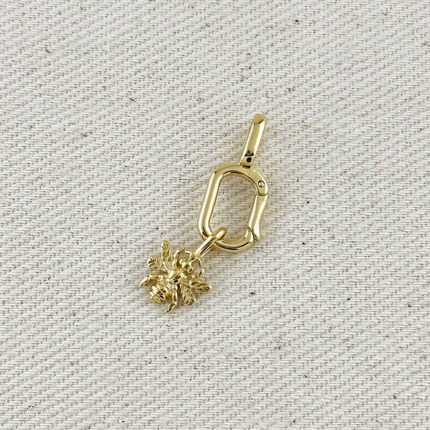 Gold  charm on a textured beige background Shop Rutledge Exchange for curated vintage and jewelry in Camden, SC.&nbsp;
