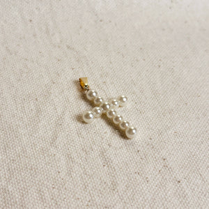Pearl cross pendant on a beige fabric background. Shop Rutledge Exchange for curated vintage and jewelry in Camden, SC.