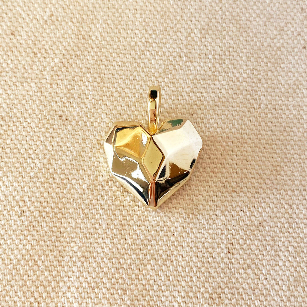 Gold geometric pendant on a beige fabric background. Shop Rutledge Exchange for curated vintage and jewelry in Camden, SC.