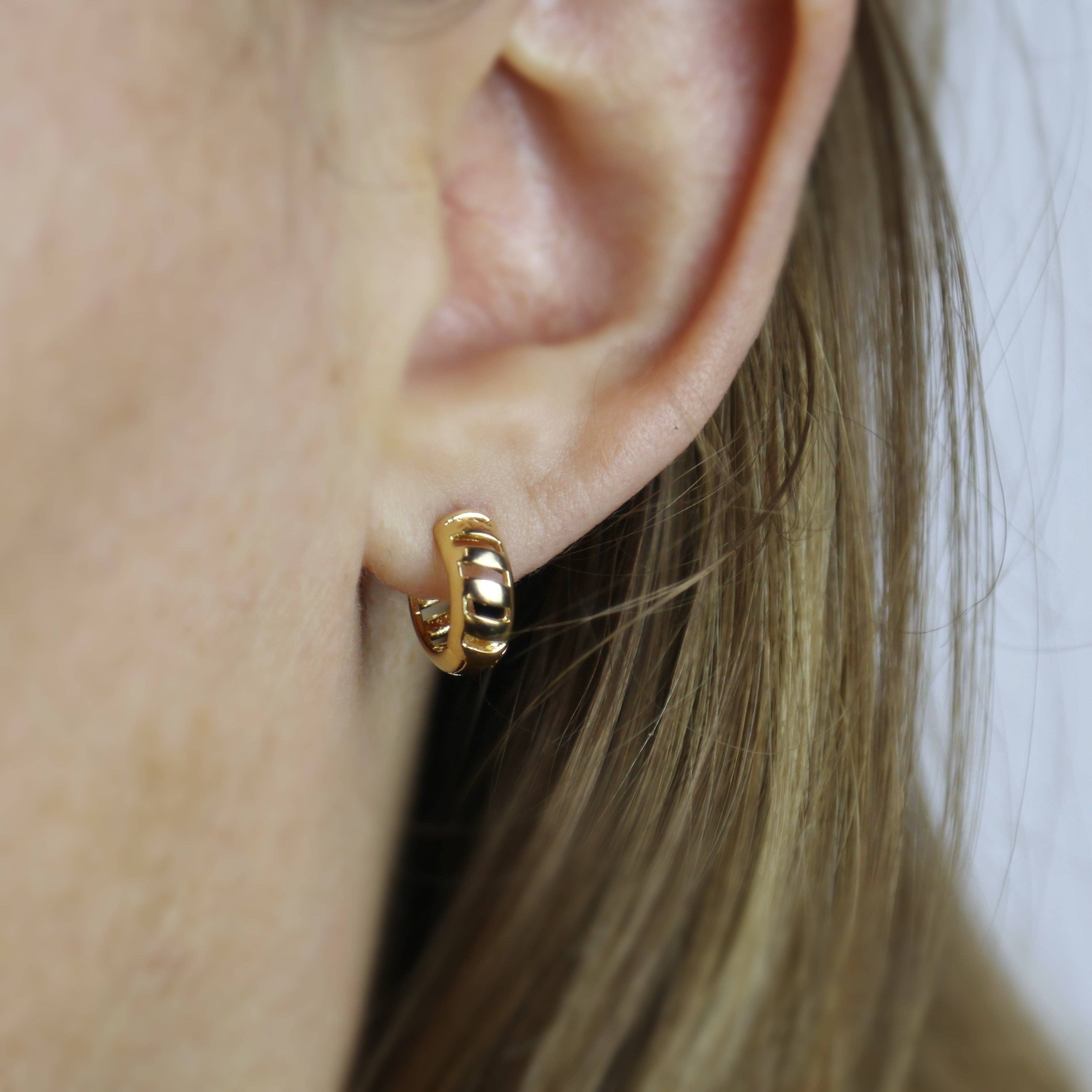 Closeup of Gold hoop earring worn by a person . Shop Rutledge Exchange for curated vintage and jewelry in Camden, SC.