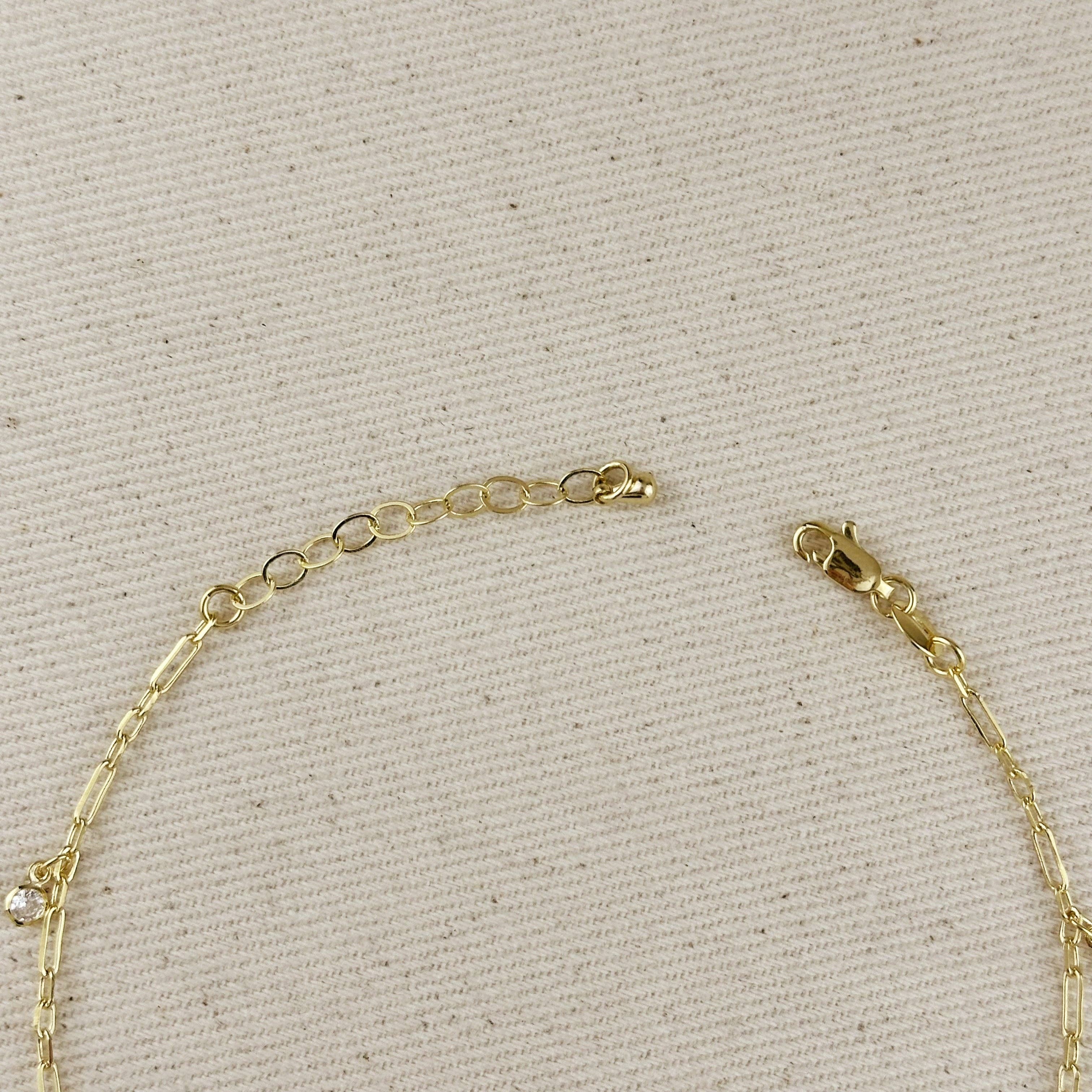 Gold bracelet on a beige textured background. Shop Rutledge Exchange for curated vintage and jewelry in Camden, SC.