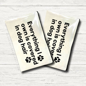 Two white towels with humorous text and paw prints on a light wooden surface. Rutledge Exchange is a boutique jewelry and antique store in Camden, SC. &nbsp;