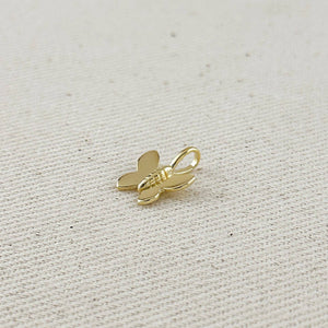Gold butterfly charm on a light fabric background