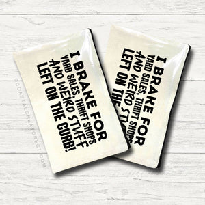 Two ceramic coasters with humorous text on a white wooden surface. Canvas pouch with text on a white wooden background at Rutledge Exchange in Camden, SC.