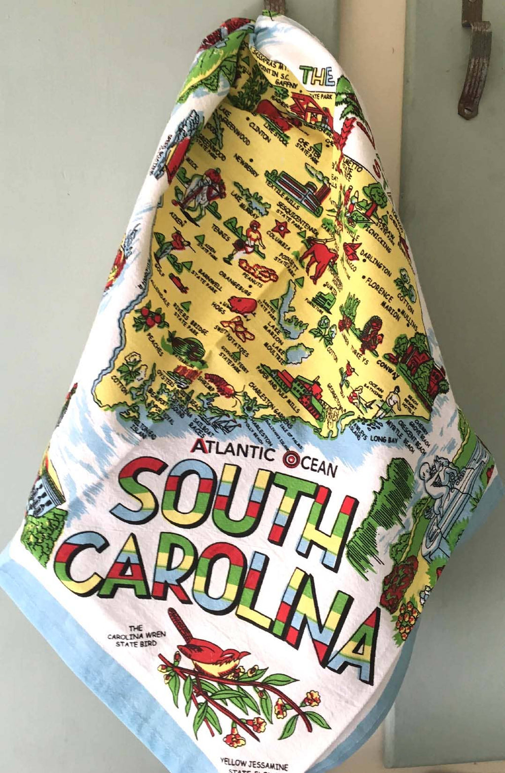 South Carolina-themed decorative towel hanging on a hook. Rutledge Exchange is a boutique jewelry and antique store in Camden, SC.