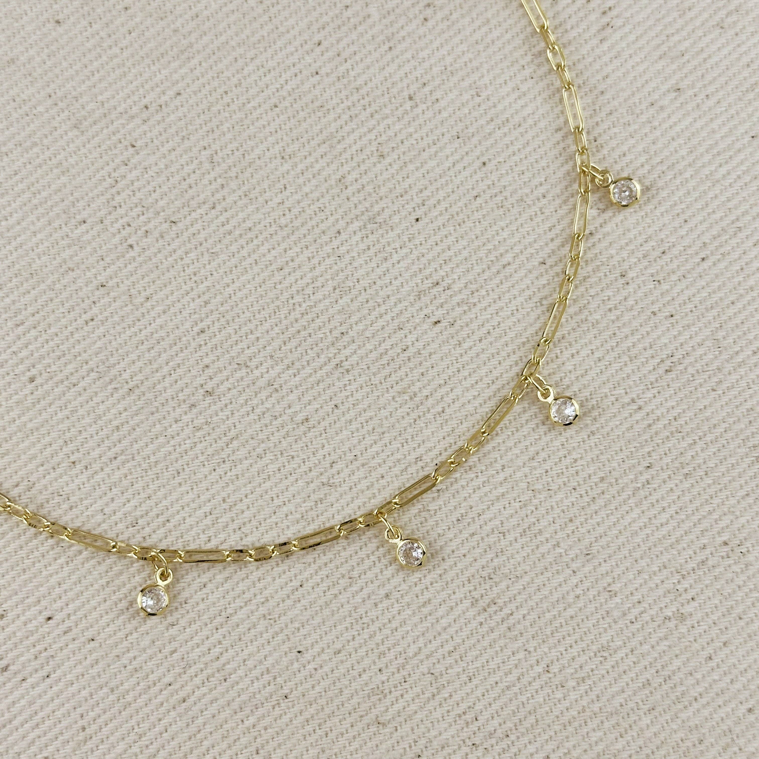 Gold necklace with small gemstones on a light gray background. Shop Rutledge Exchange for curated vintage and jewelry in Camden, SC.