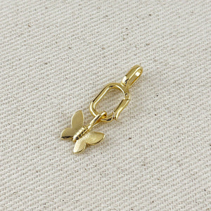Gold butterfly charm on a textured beige background