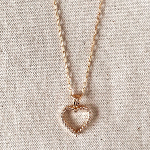 Rose gold heart-shaped pendant necklace on a textured beige background. Shop Rutledge Exchange for curated vintage and jewelry in Camden, SC.