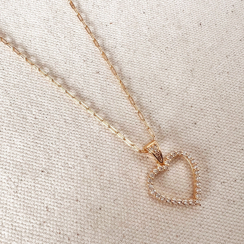 Rose gold heart-shaped necklace on a textured beige surface. Shop Rutledge Exchange for curated vintage and jewelry in Camden, SC.