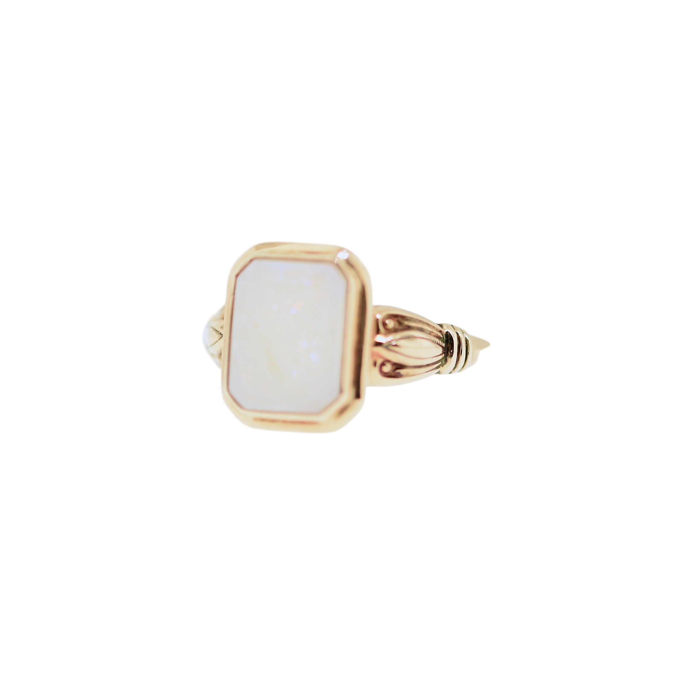Gold ring with a white stone on a white background