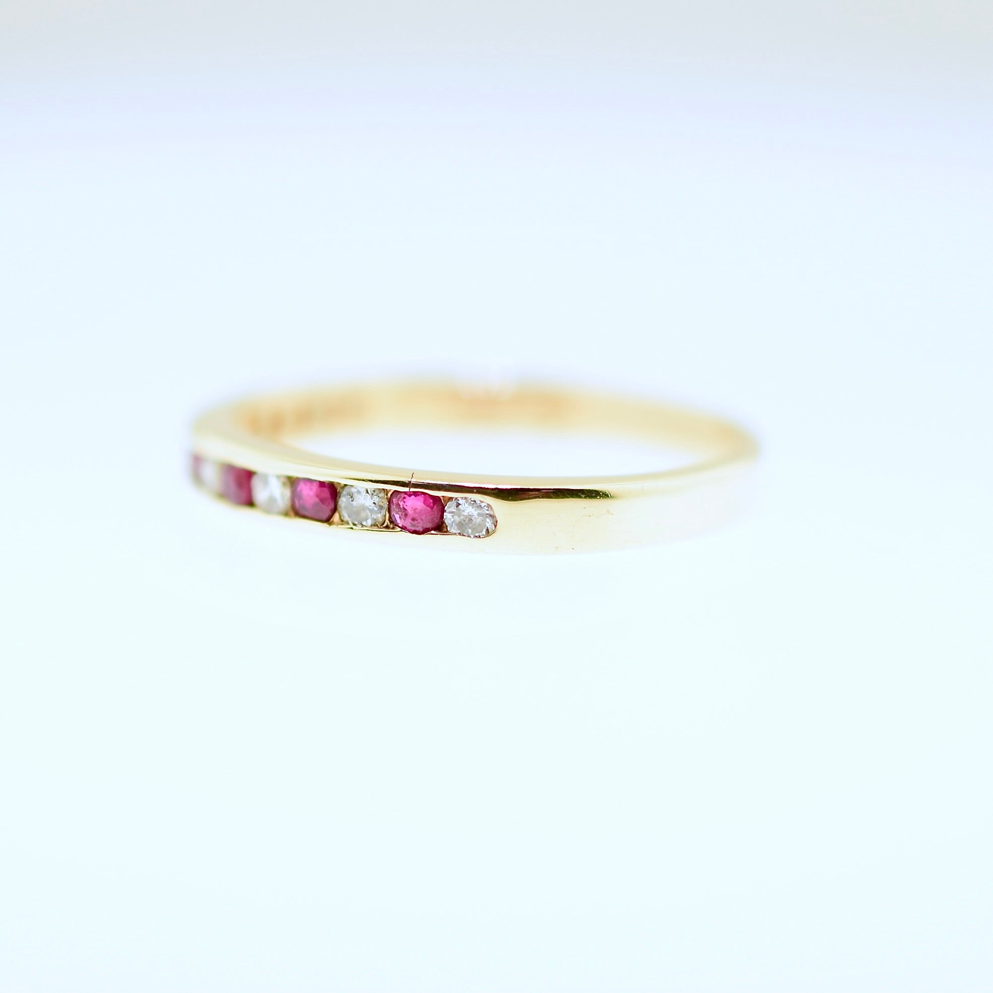 Gold ring with embedded gemstones on a white background. Shop curated jewelry and antiques at Rutledge Exchange in Camden, SC.