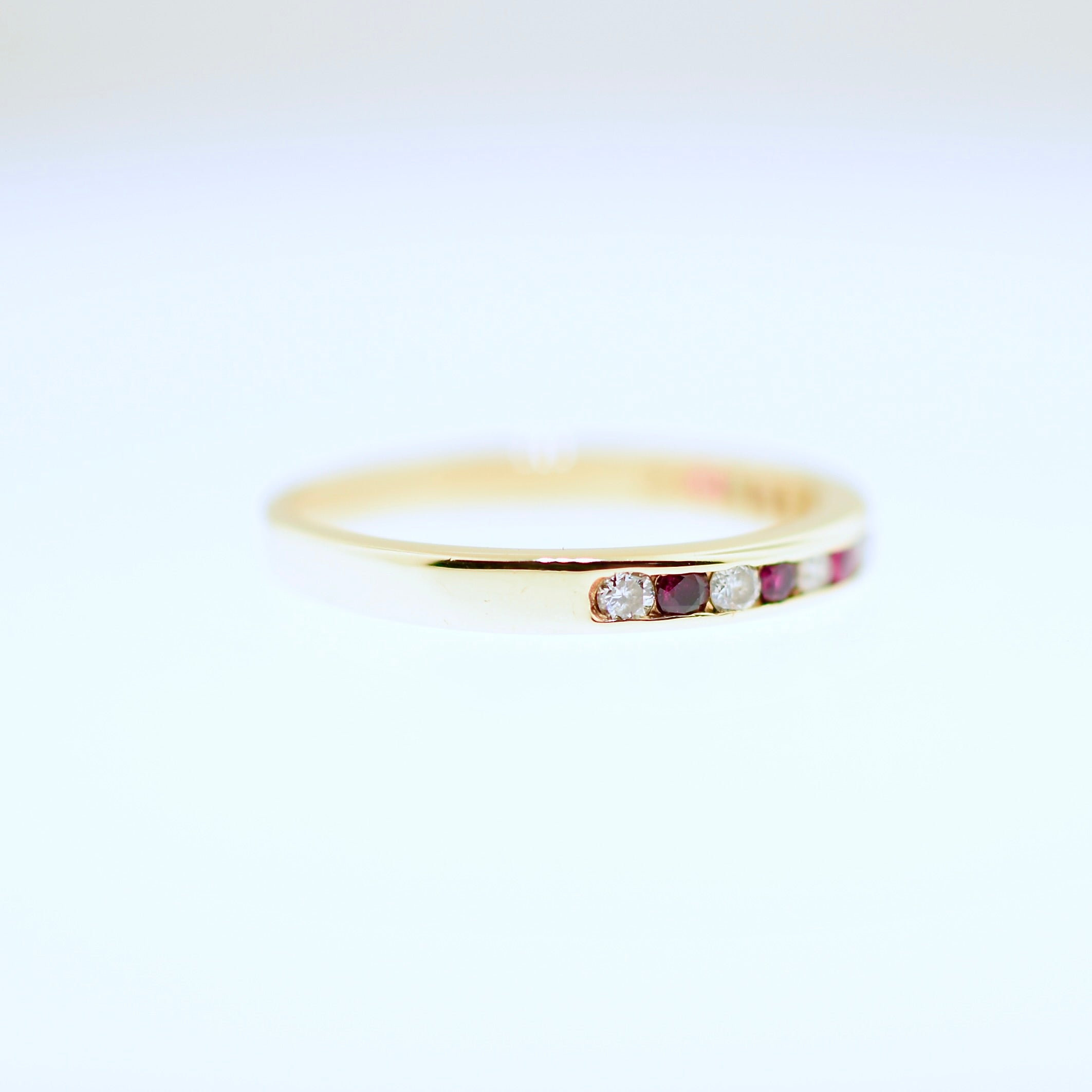 Gold ring with embedded gemstones on a white background. Shop curated jewelry and antiques at Rutledge Exchange in Camden, SC.