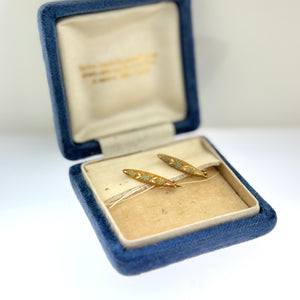 Gold brooches in an open blue velvet jewelry box on a white background at Rutledge Exchange in Camden SC