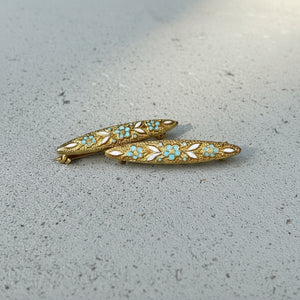 Two decorative brooches on a textured surface at Rutledge Exchange in Camden, SC