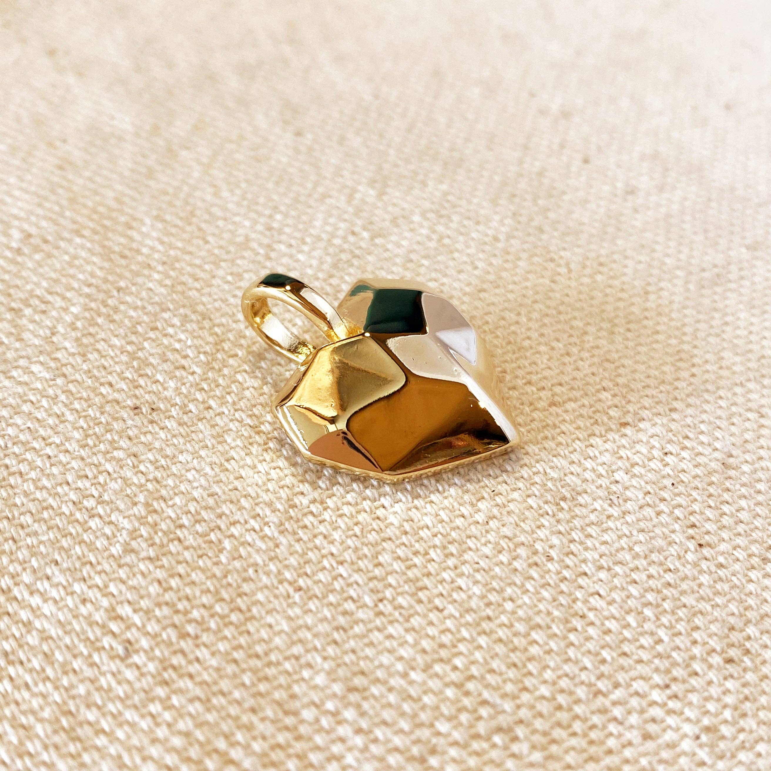 Gold pendant on a beige fabric background. Shop Rutledge Exchange for curated vintage and jewelry in Camden, SC