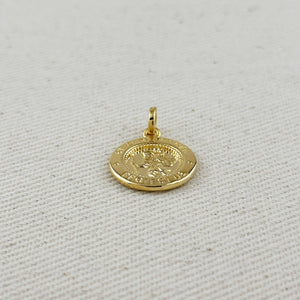 Gold pendant on a light gray fabric background. Shop Rutledge Exchange for curated vintage and jewelry in Camden, SC.&nbsp;