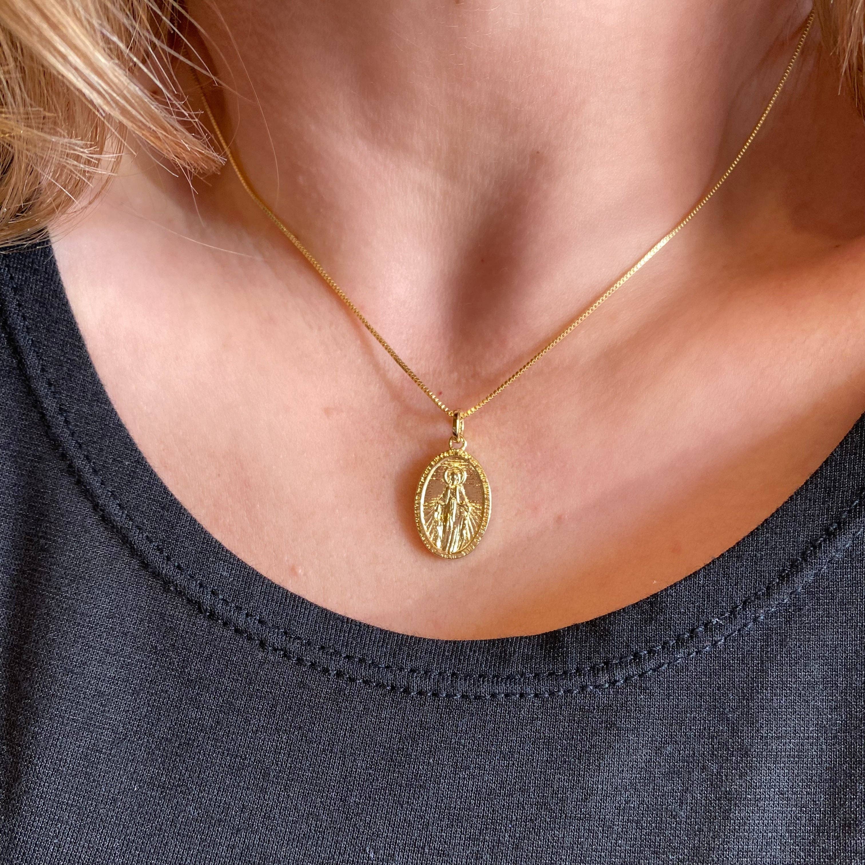 Gold necklace with a pendant worn by a person against a dark background. 
Shop Rutledge Exchange for curated vintage and jewelry in Camden, SC.&nbsp;