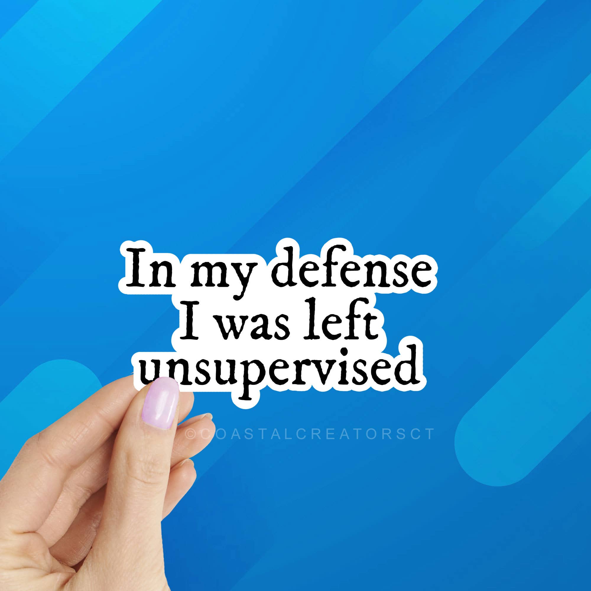 Text 'In my defense I was left unsupervised' held by a hand against a blue geometric background. In My Defense I Was Left Unsupervised Laptop Kindle Sticker
