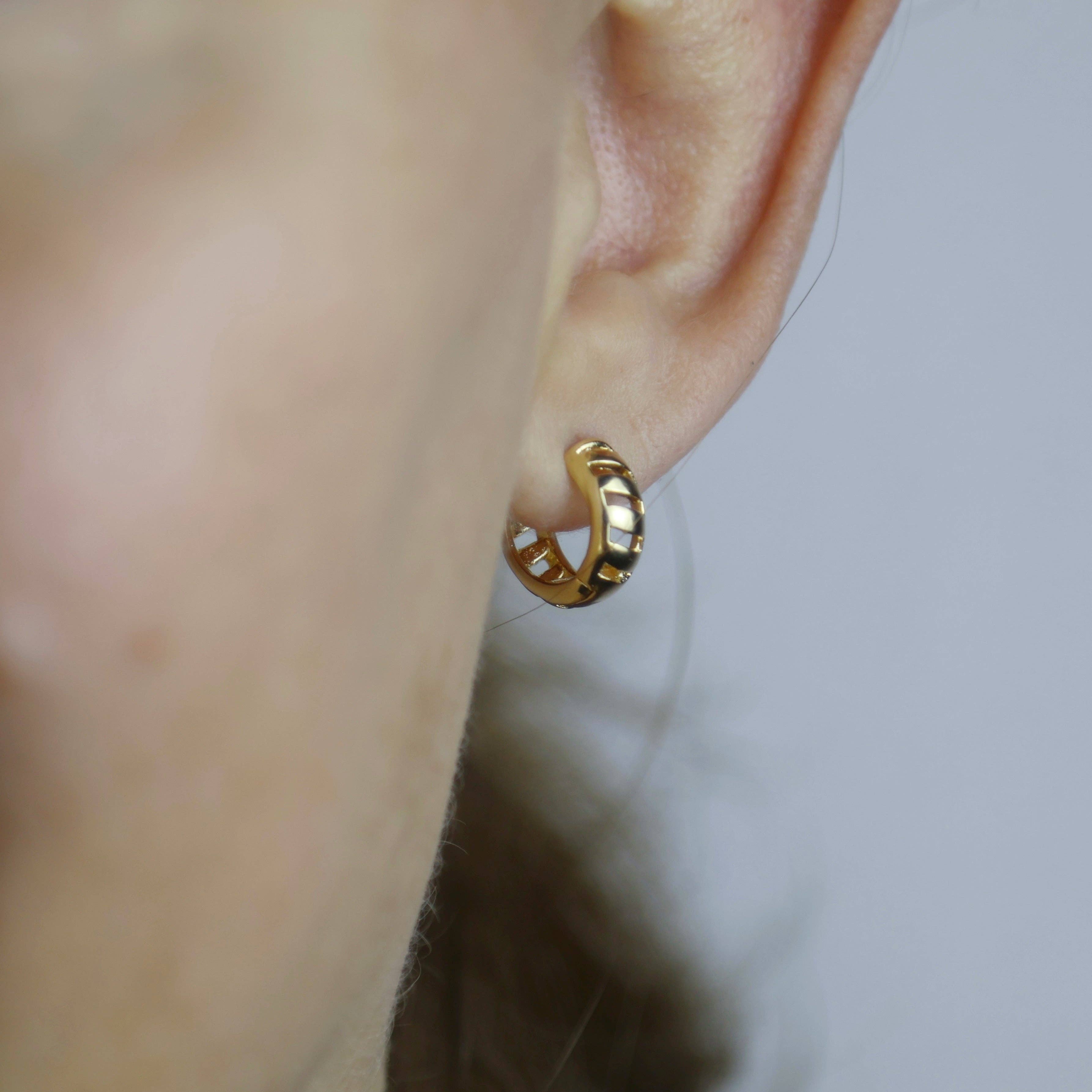 Gold hoop earring worn on a person's ear with a neutral background. Shop Rutledge Exchange for curated vintage and jewelry in Camden, SC.