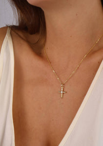 Gold necklace with a cross pendant worn by a person. Shop Rutledge Exchange for curated vintage and jewelry in Camden, SC.