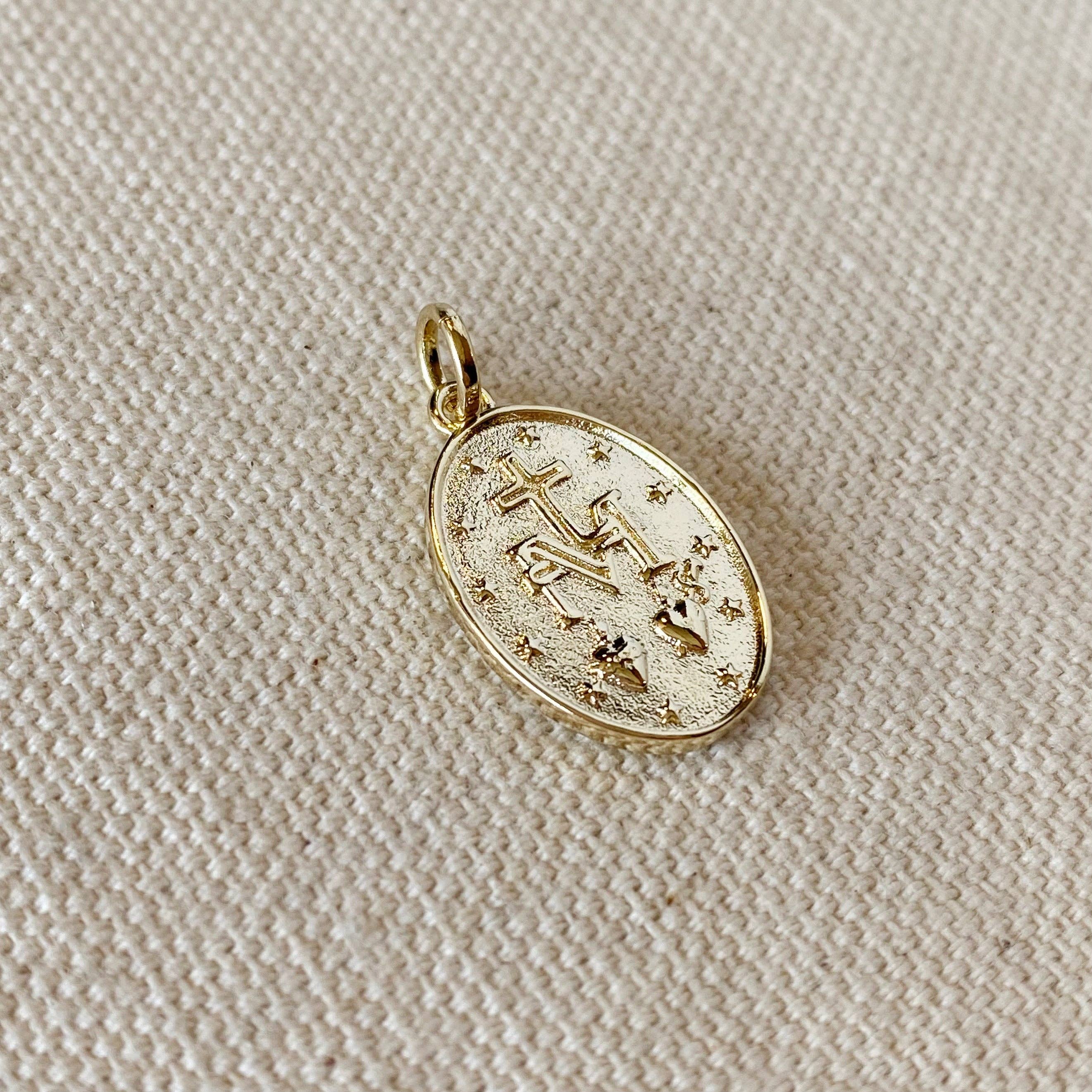 Gold pendant with star design on a beige fabric background. 
Shop Rutledge Exchange for curated vintage and jewelry in Camden, SC.&nbsp;
