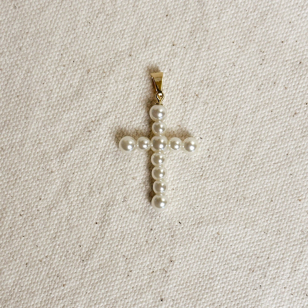 Pearl cross pendant on a beige fabric background Shop Rutledge Exchange for curated vintage and jewelry in Camden, SC.