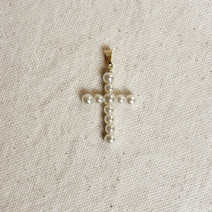 Pearl cross pendant on a beige fabric background Shop Rutledge Exchange for curated vintage and jewelry in Camden, SC.