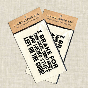 Canvas zipper bags with humorous text on a textured beige background. 