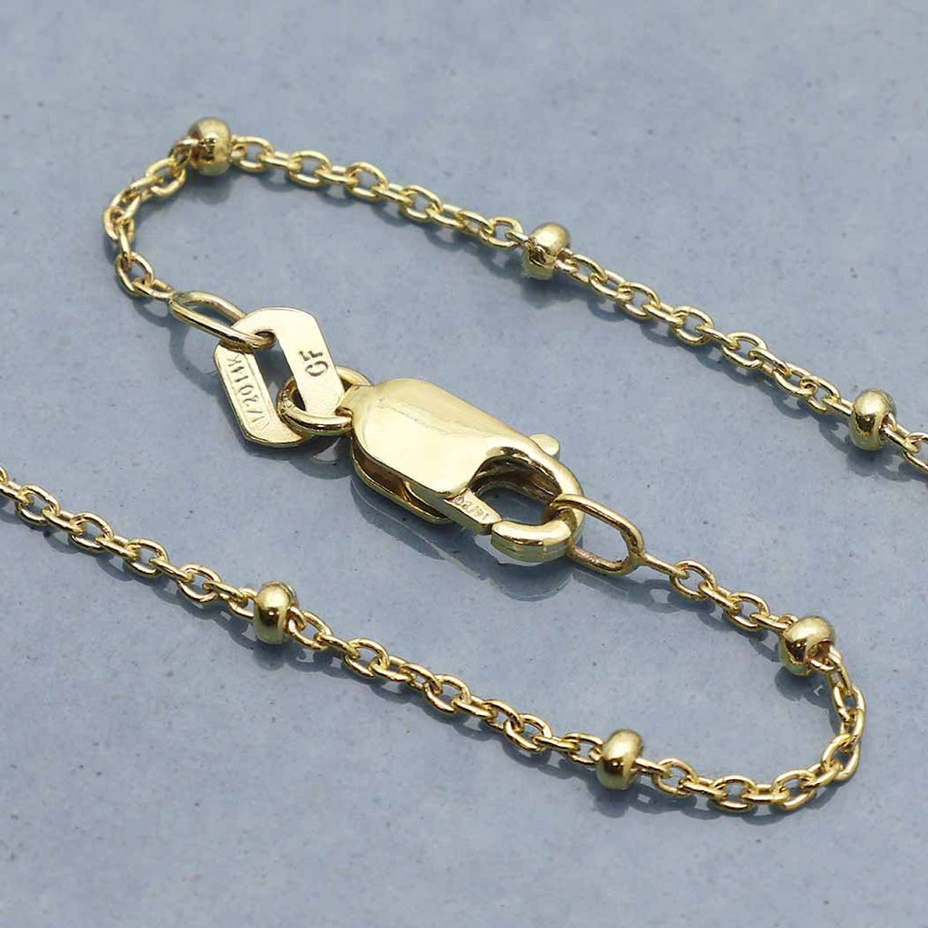 This gold filled satellite chain is perfect for creating charm necklaces. This curb chain feels lovely, each link is flatted and twisted to create a tightly linked sturdy chain. Each link measures approximately 2mm x 1mm and features a 8mm lobster clasp. This is a dainty satellite chain composed of tiny round links punctuated with gold beads that add a rich texture.  Wear on its own or with a charm. Perfect layering piece.
