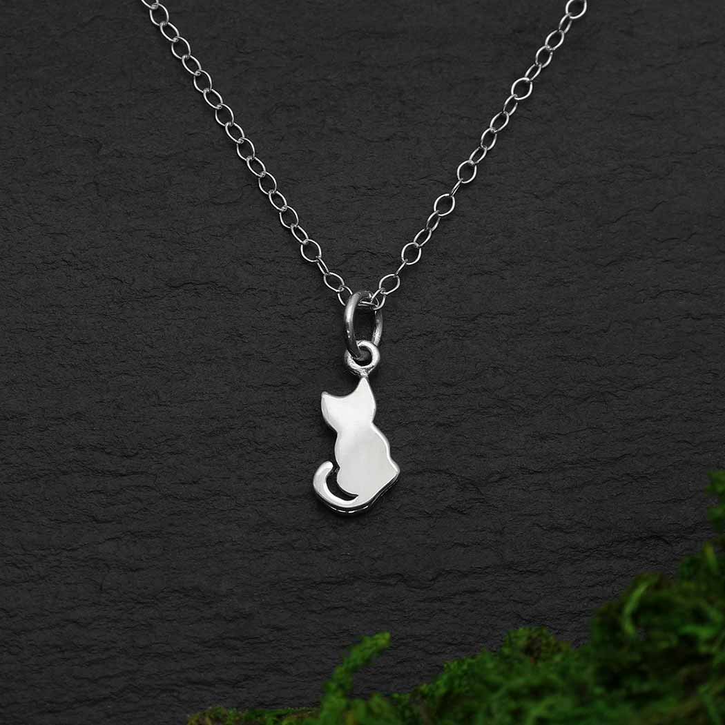This sterling silver tiny cat charm necklace is a universal visual of a cat sitting patiently, just watching the world go by. We love her because she teaches us the joy of missing out, appreciating the little things, and of letting go of all our worry. While this tiny cat charm necklace is perfect for Youth and Jr Jewelry Lines, they'll also put a smile on cat lover's of all ages.  Rutledge Exchange